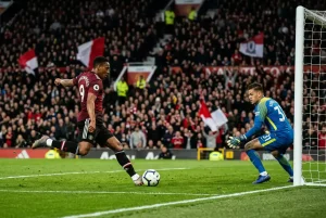 Attaquant de Premier League en position de tir devant le but